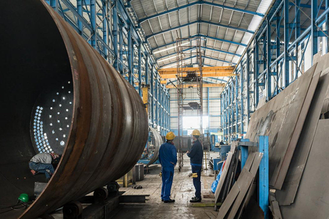 Image of two men in hard hats within a steel fabrication warehouse illustrating the small industrial manufacturing sector in Parramatta. 