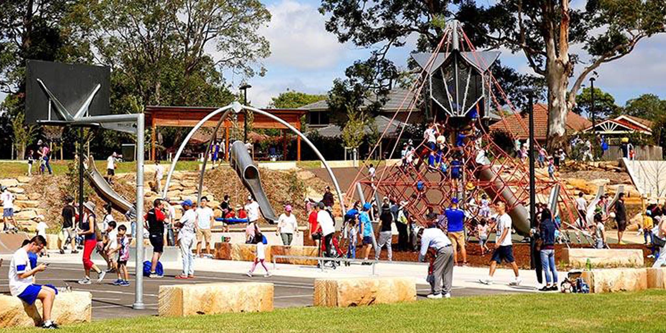 Image of children and parents at a busy state of the art playground on a sunny weekend