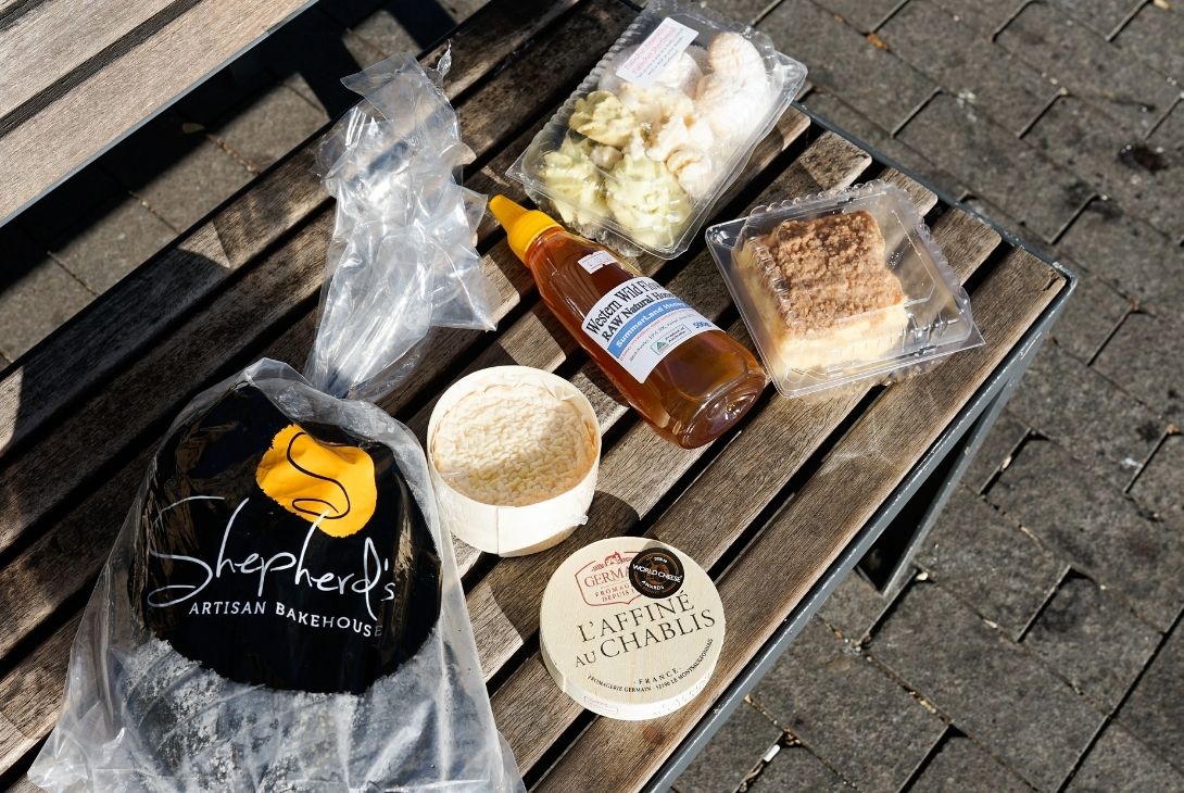 bread, cheese and honey from farmers markets on a picnic bench