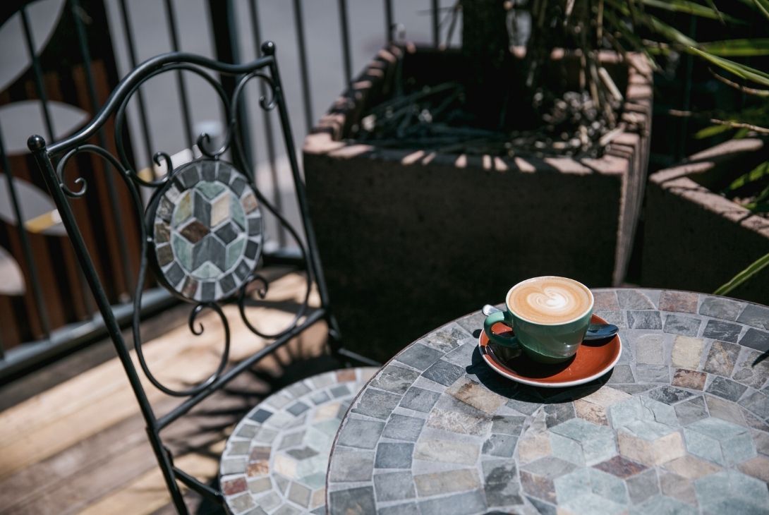 cup of coffee on outdoor table and chair set