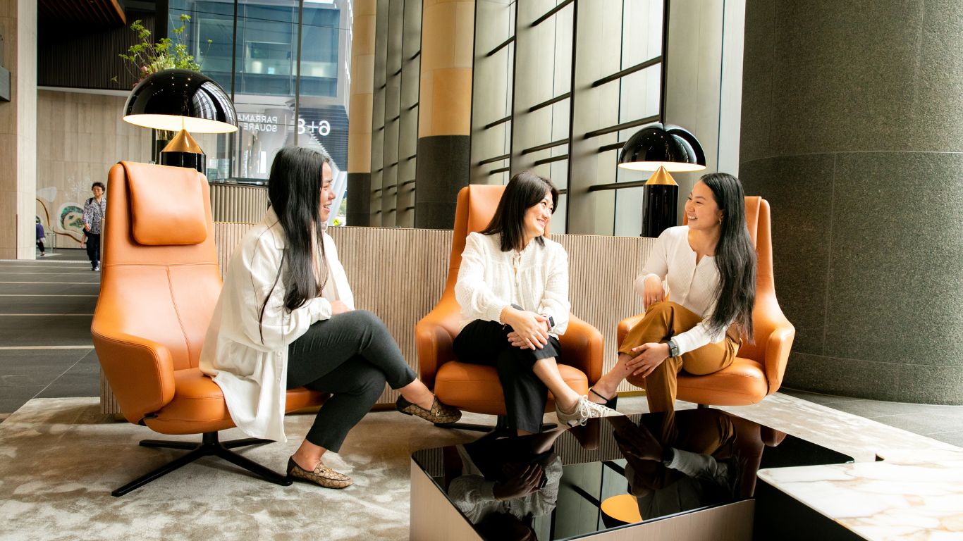Three women sitting on chairs