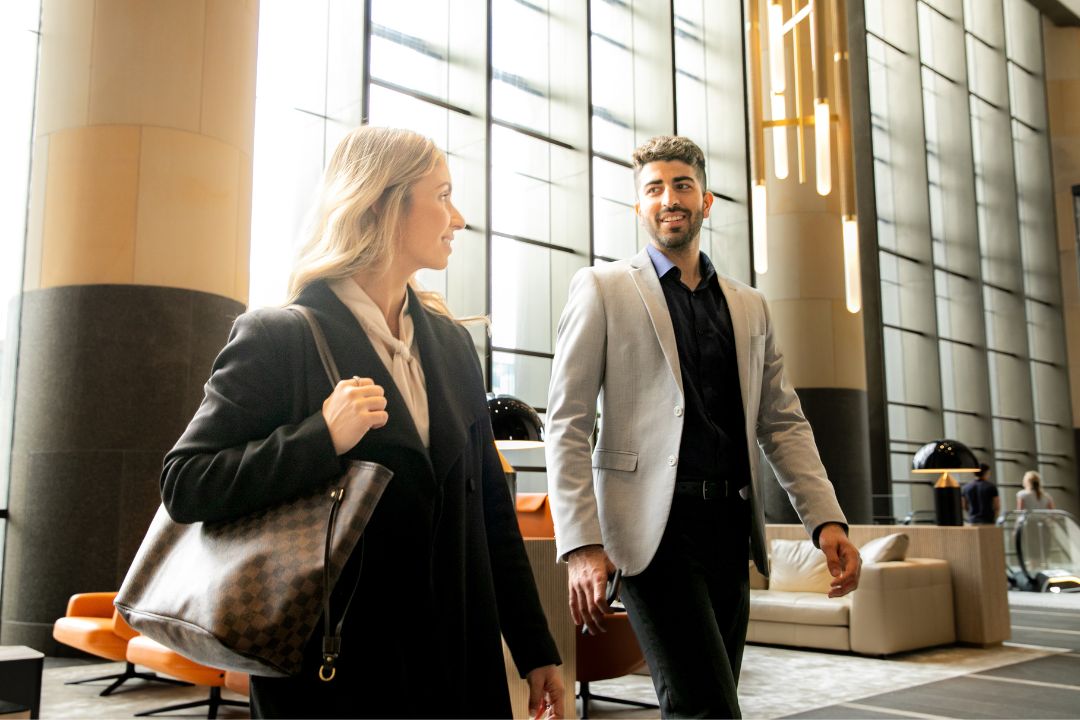 Two office workers walking into a building lobby.