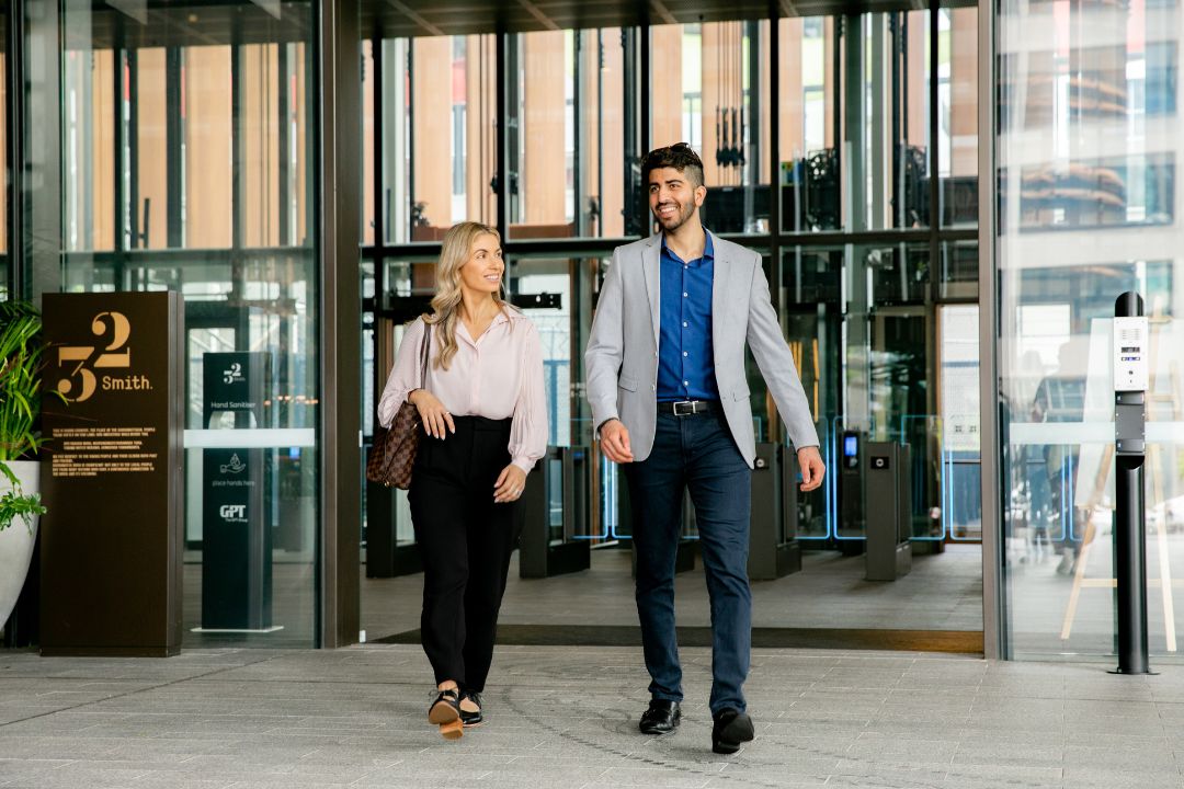 Two office workers walking out of a building