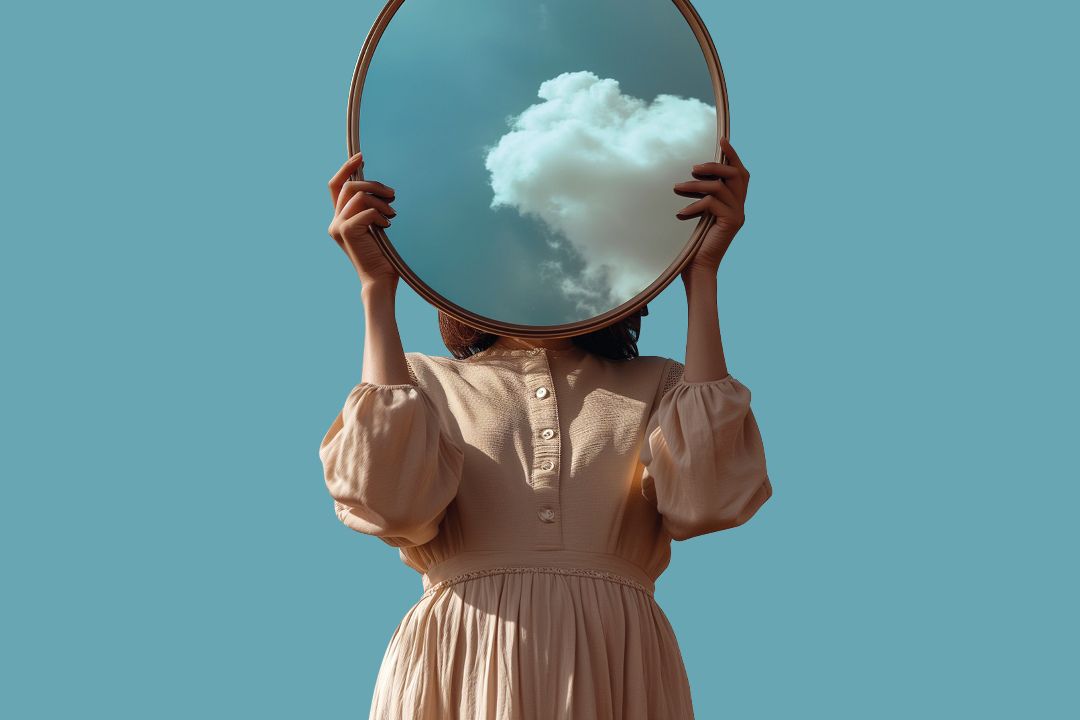 women holding mirror reflecting blue sky
