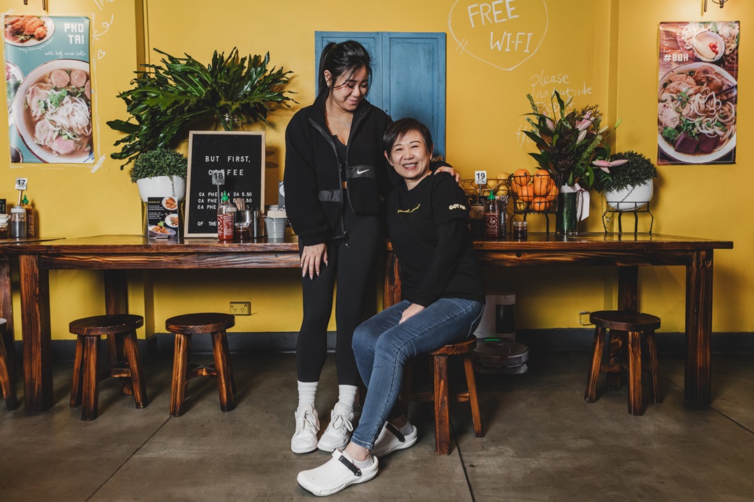 Two women, one sitting down in a food store