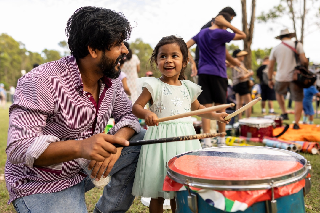 Young kid and father hitting a drum