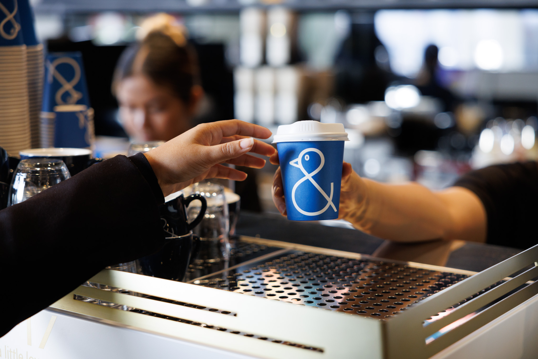Blue Coffee cup with a duck being handed to customer
