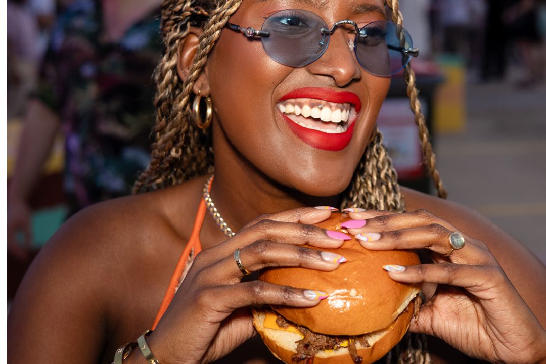 Woman smiling and holding a burger