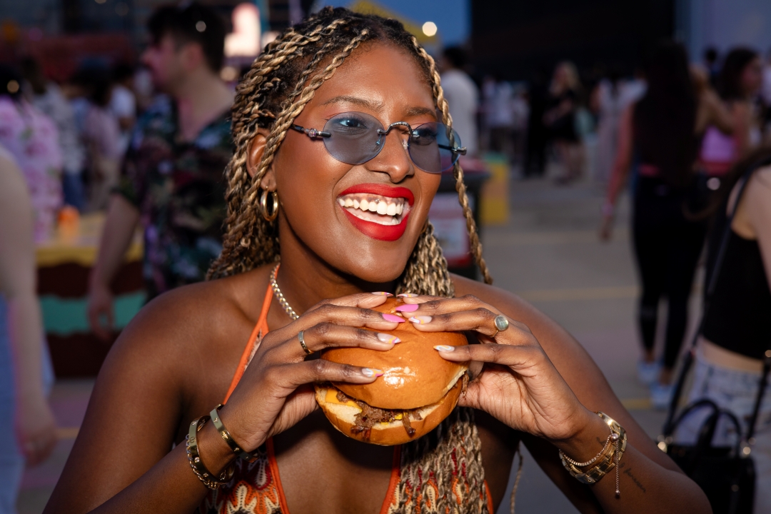 Smiling woman holding a burger