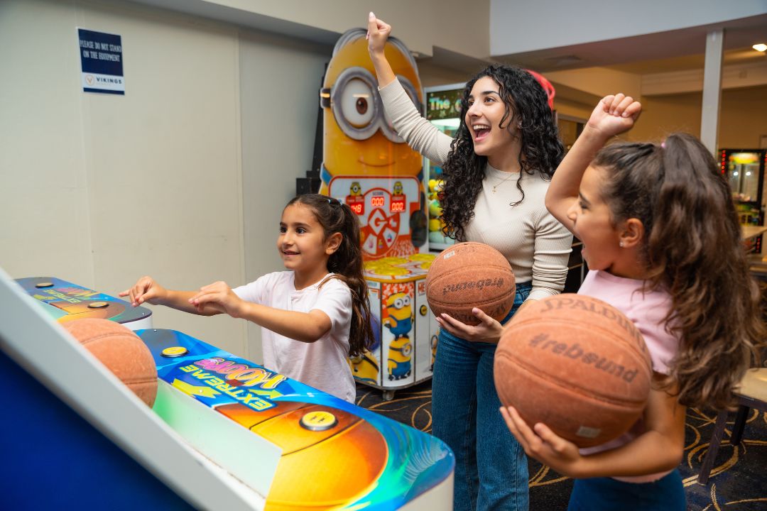 Family playing basketball in an arcade