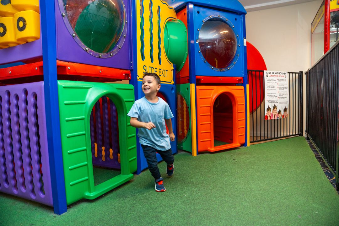 Little boy running within indoor playground
