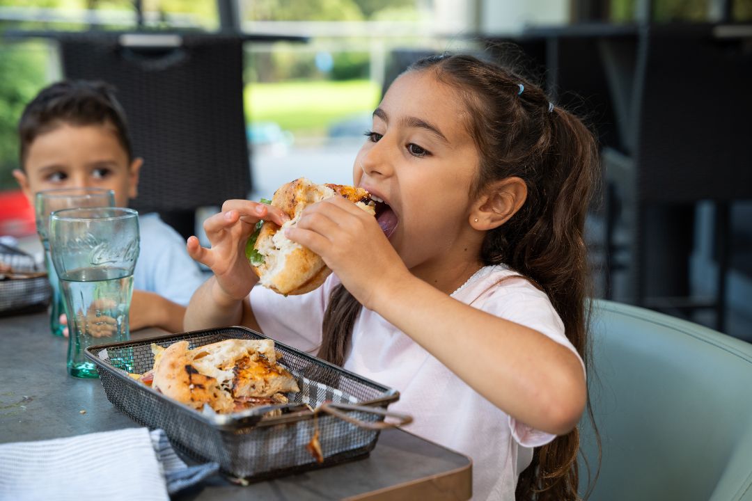 Little girl eating a yummy burger