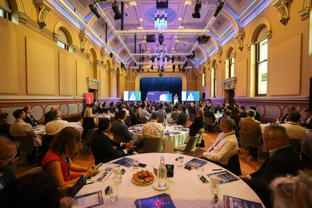 Large room of people sitting around circle tables