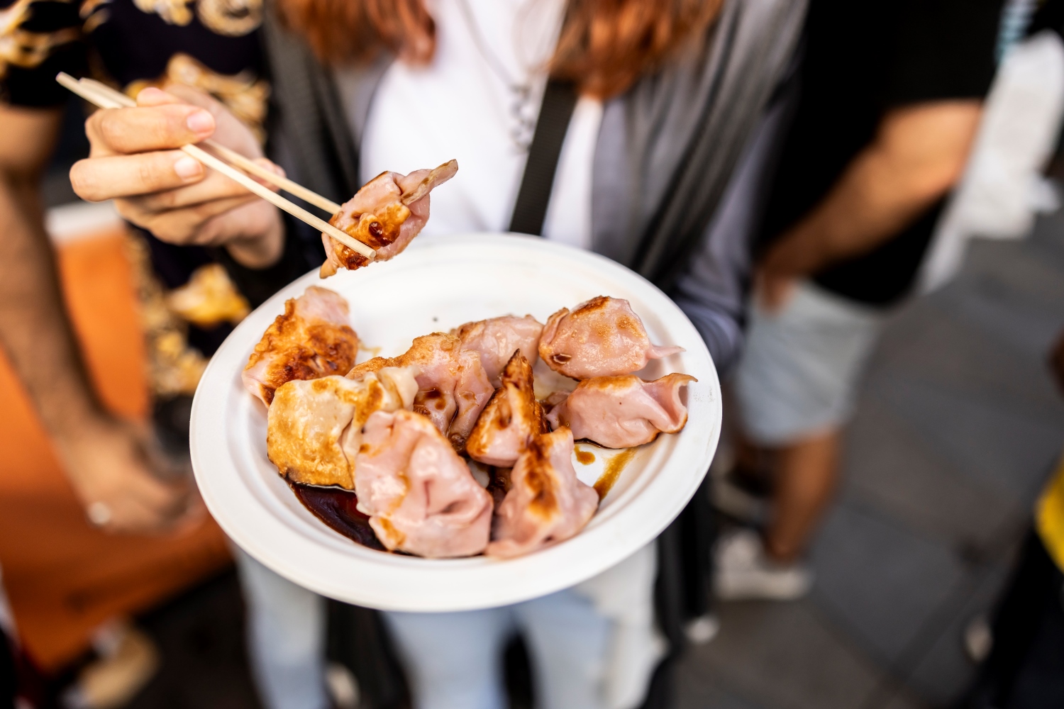 Hand holding a Plate of dumplings