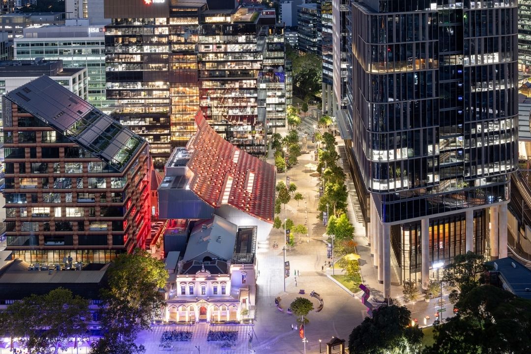 Aerial view of lit up buildings in city at night time