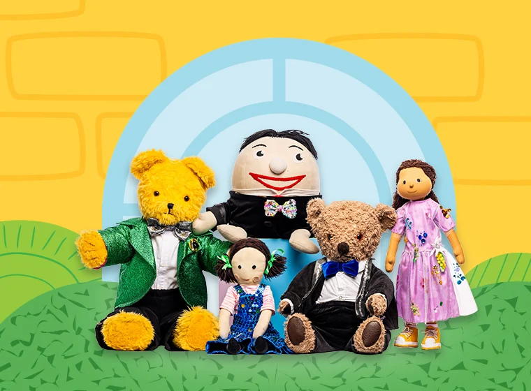 A cheerful group of colorful stuffed toys includes two bears in suits, a doll in a blue dress, a smiling round figure, and a doll in a floral dress.