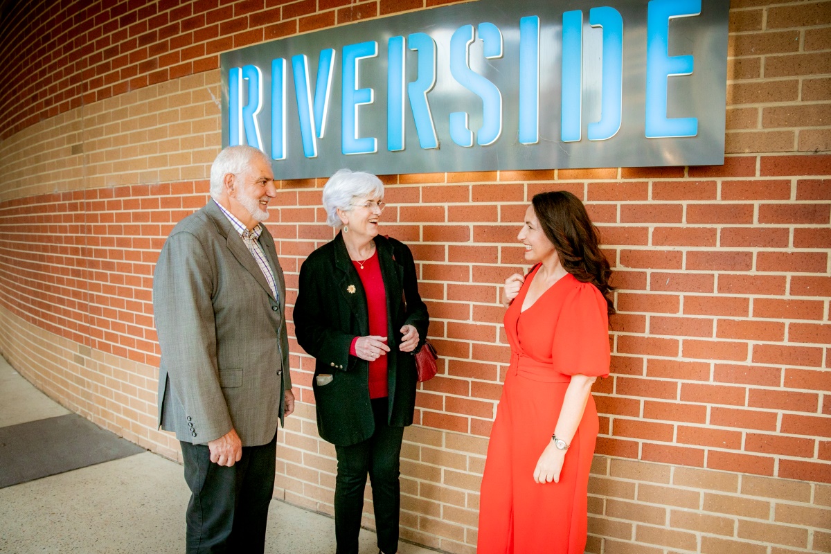 Elderly couple with woman in red jumpsuit