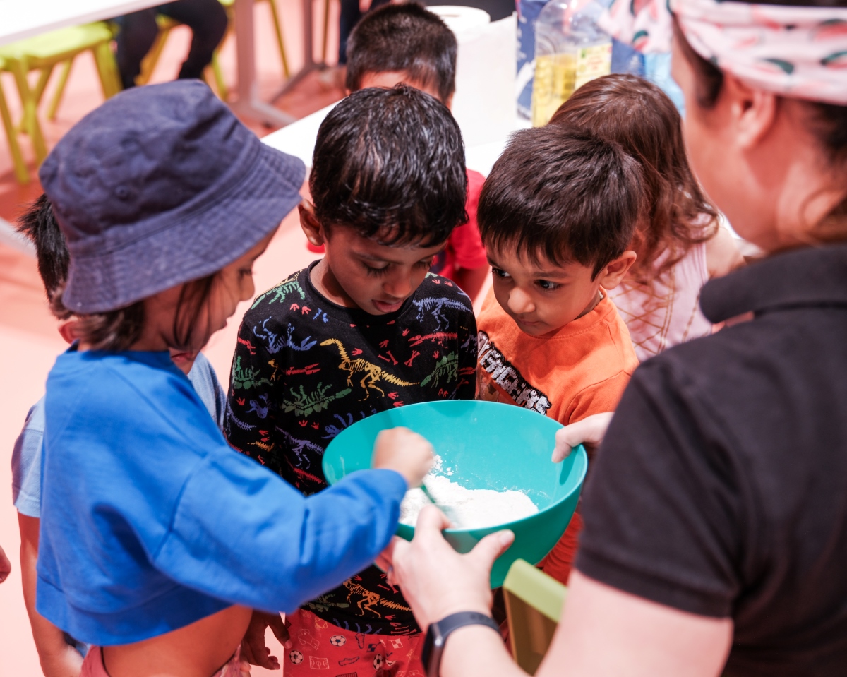 Three children mixing a teal bowl