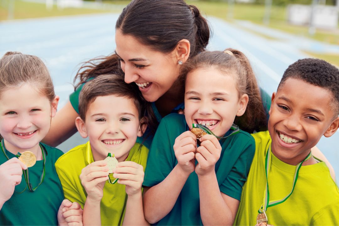 Children smiling and holding medals