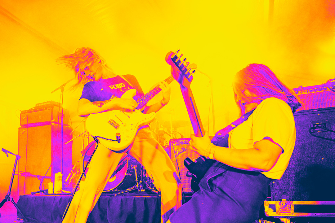 2 people playing guitar with yellow and purple glow