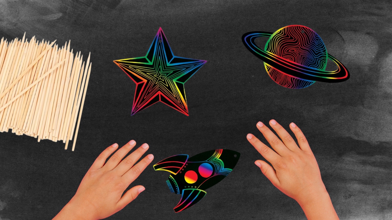 Hands on desk with black top, scratch artwork with space theme