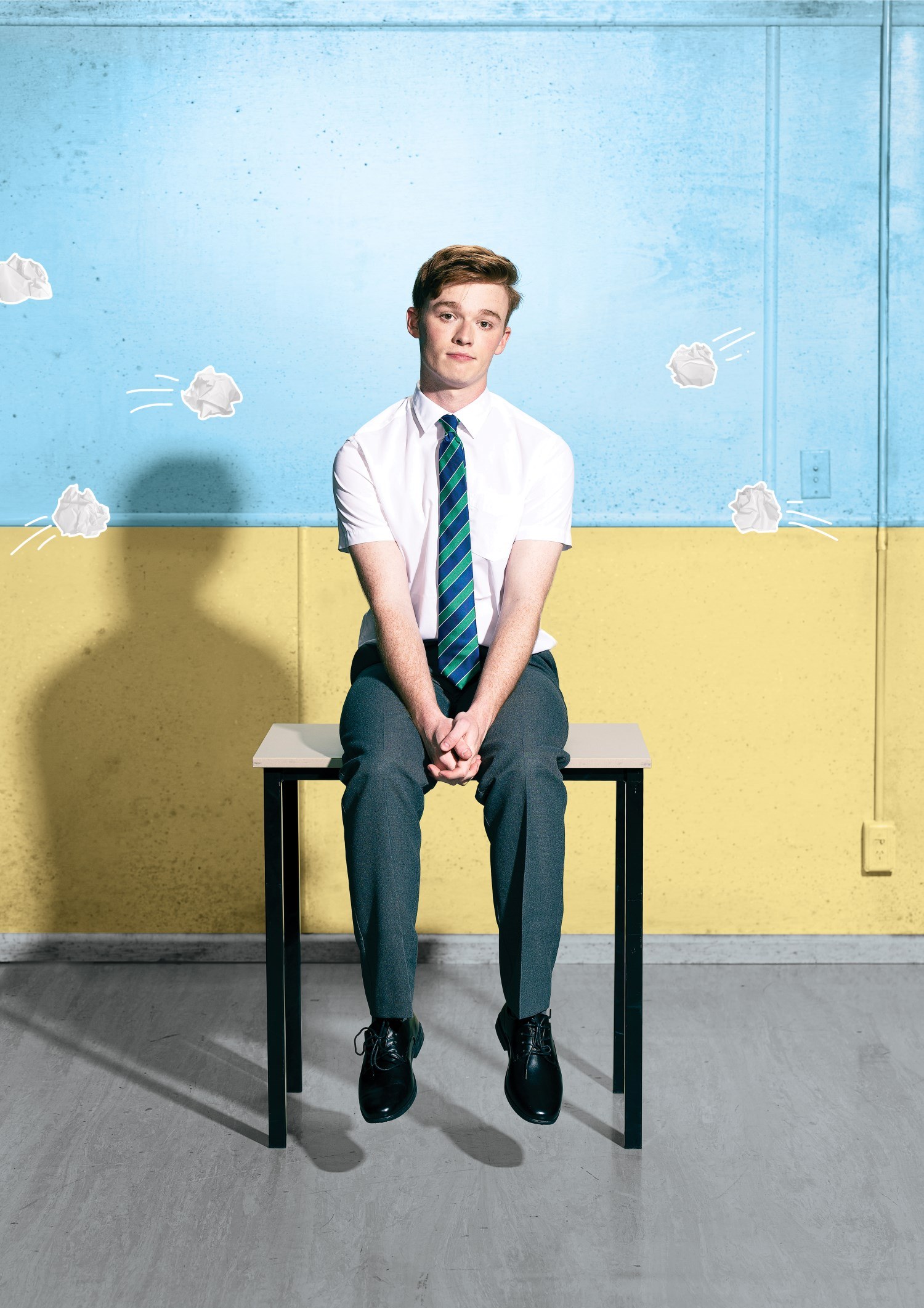 Boy sitting on a desk in a classroom