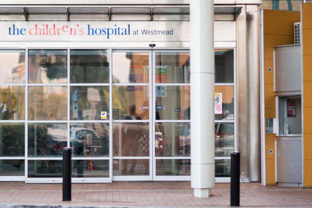 Image of the entrance to Westmead Childrens Hospital. The colourful logo baring the same name is at the top of the entryway 