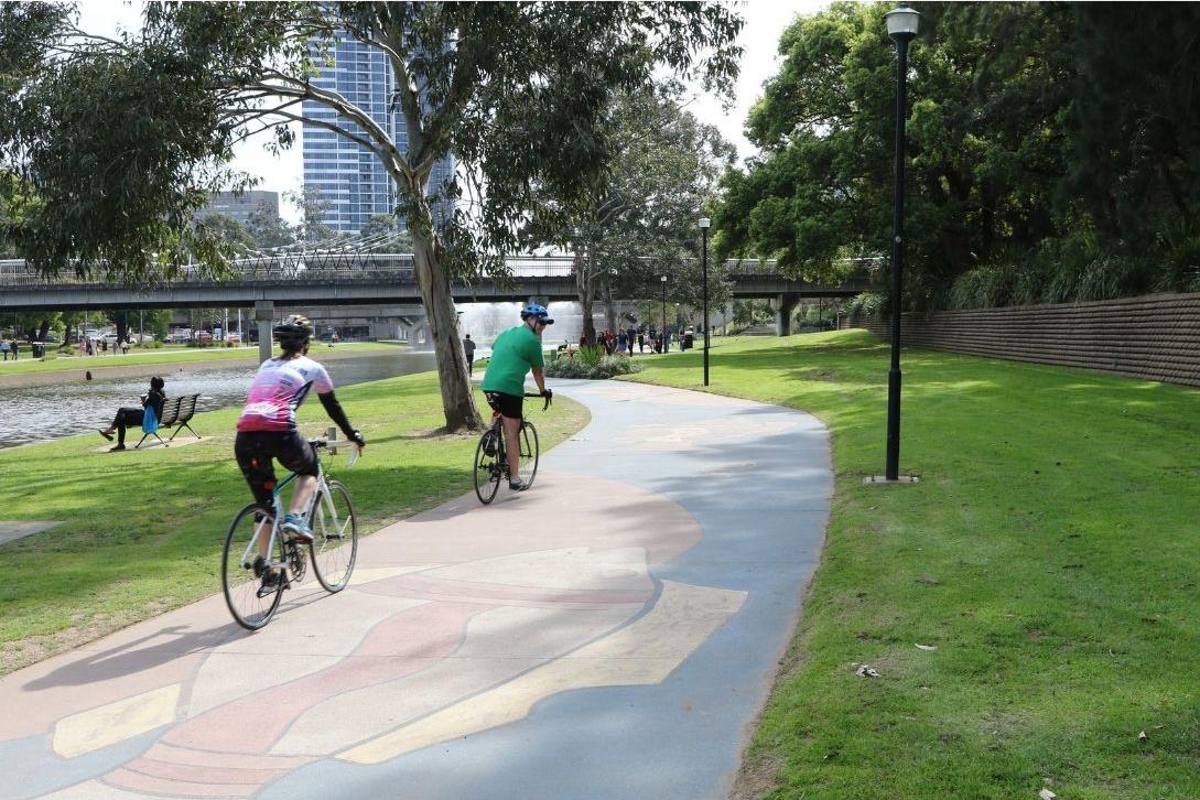 two cyclists riding the path near Parramatta River