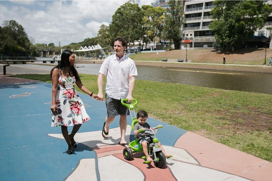 mother, father and child walking along Parramatta river