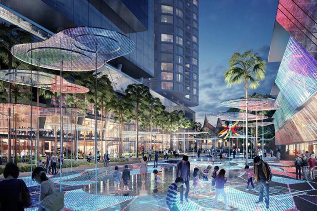 Architects rendering of residents engaged in recreational activity in the public domain of Parramatta Square.  Illustrated are parents and children playing on an interactive lighted floor display while others mingle in the nearby restaurants. 