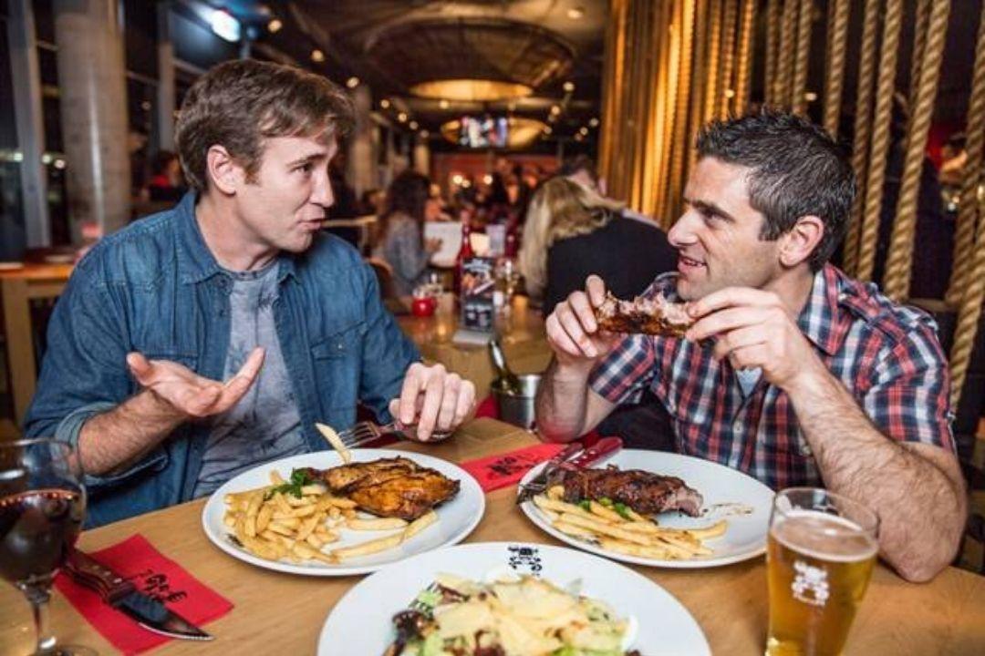 Two men eating ribs