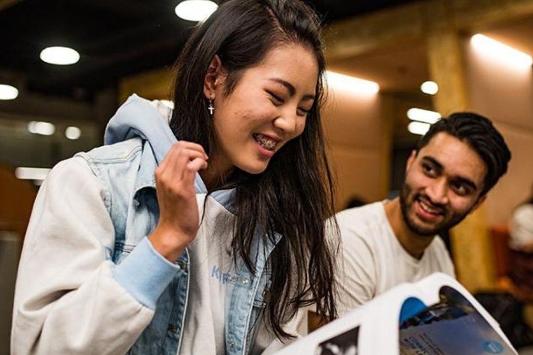 male and female students looking at a text book