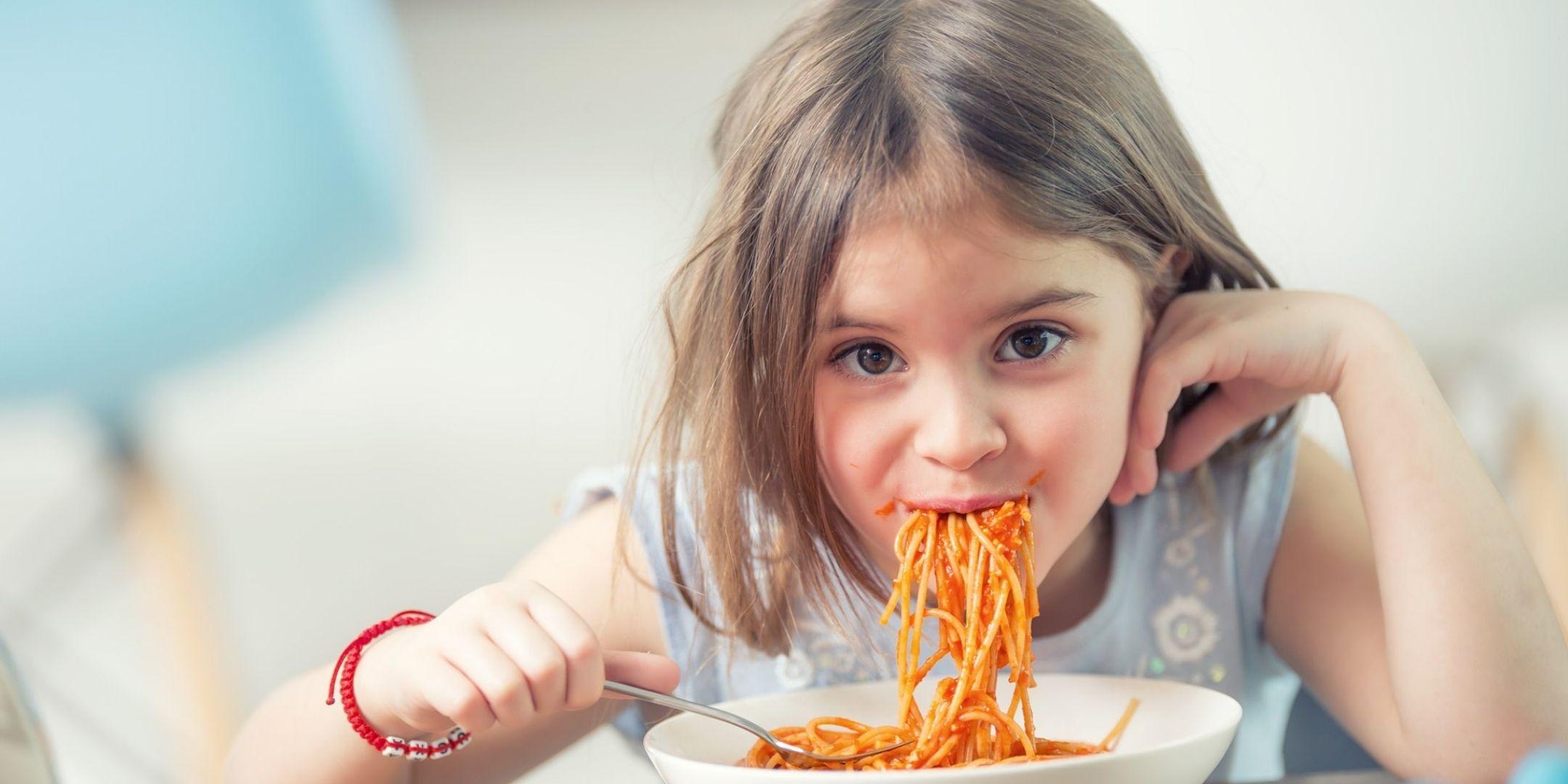 young girls slurping spaghetti