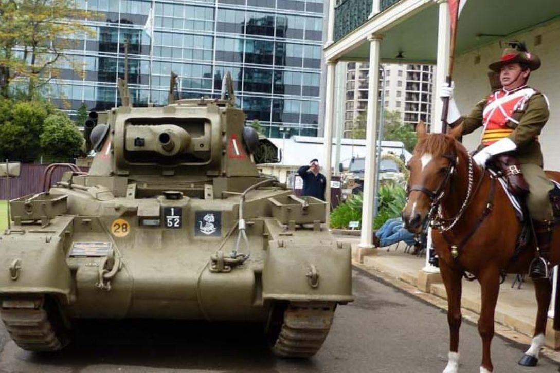 soldier on horseback next to a military tank