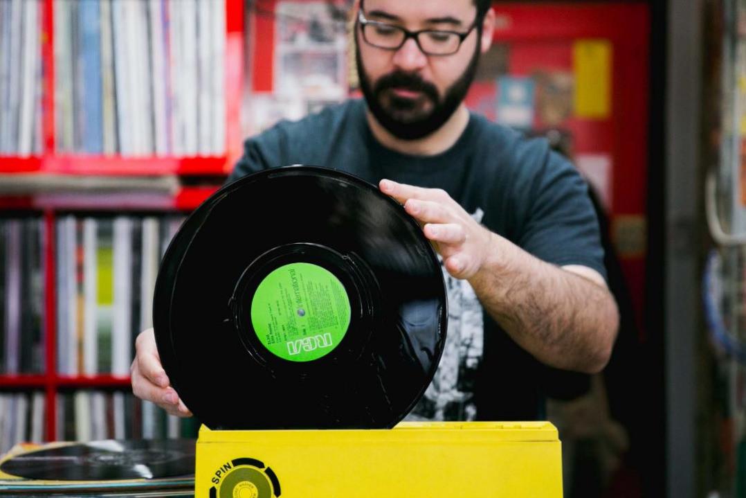 Staff person at Beat Disc records, Parramatta's only vinyl record store sorts though some of the vintages products on offer. 