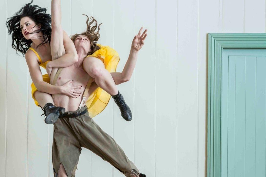 man lifting a woman in a yellow dress up in the air