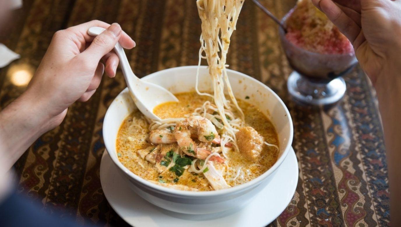 Person eating prawn laksa