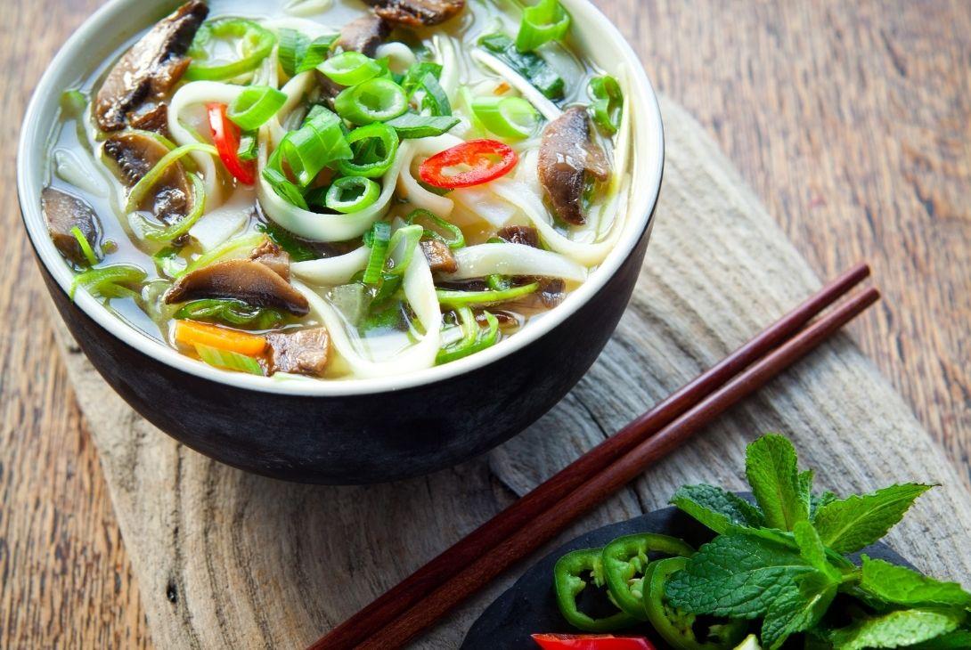vegetarian vietnamese pho in a bowl with chopsticks placed next to the bowl