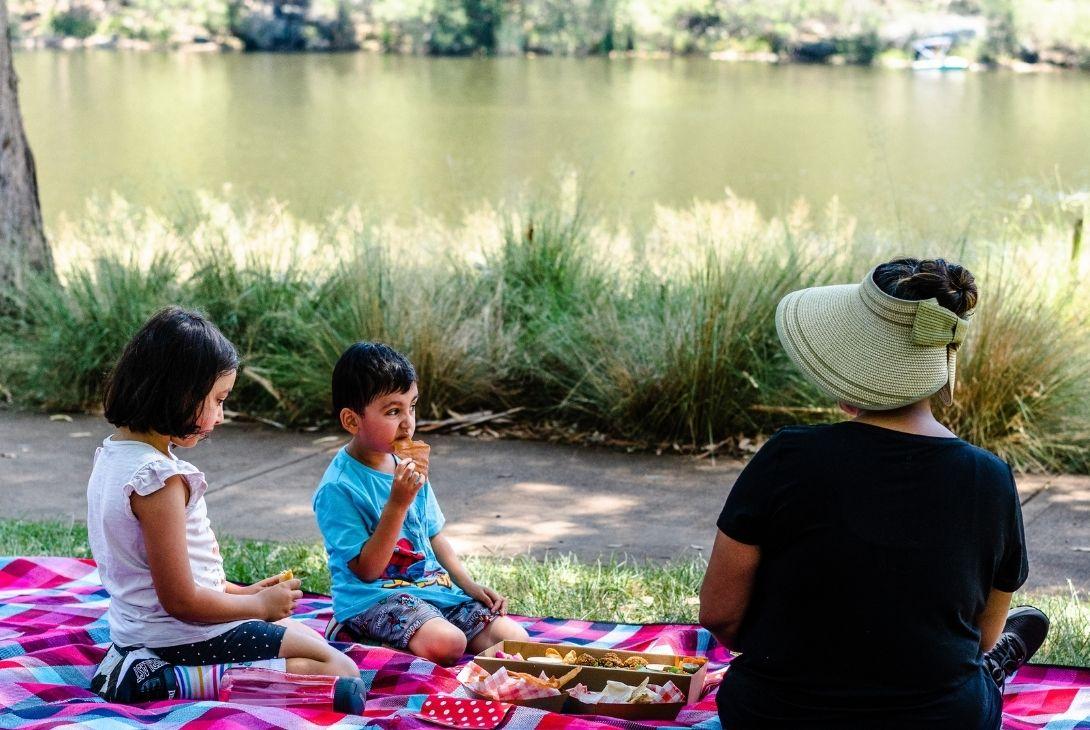 family enjoying a picnic next to lake parramatta