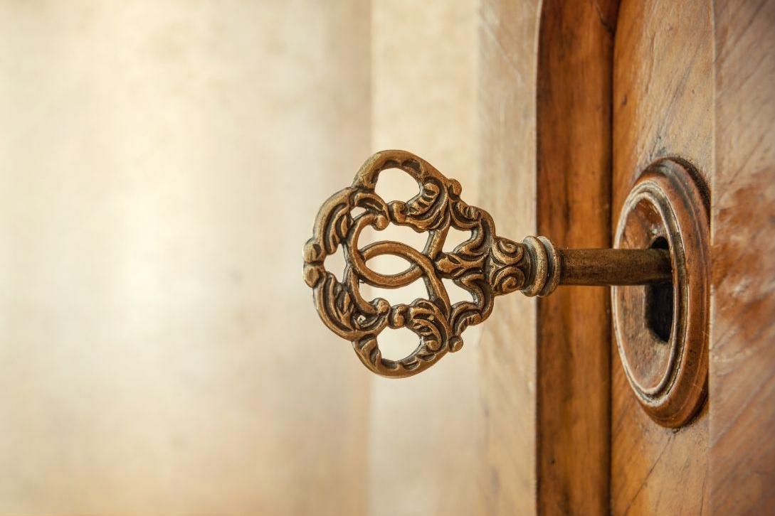 old ornate key in a wooden door 