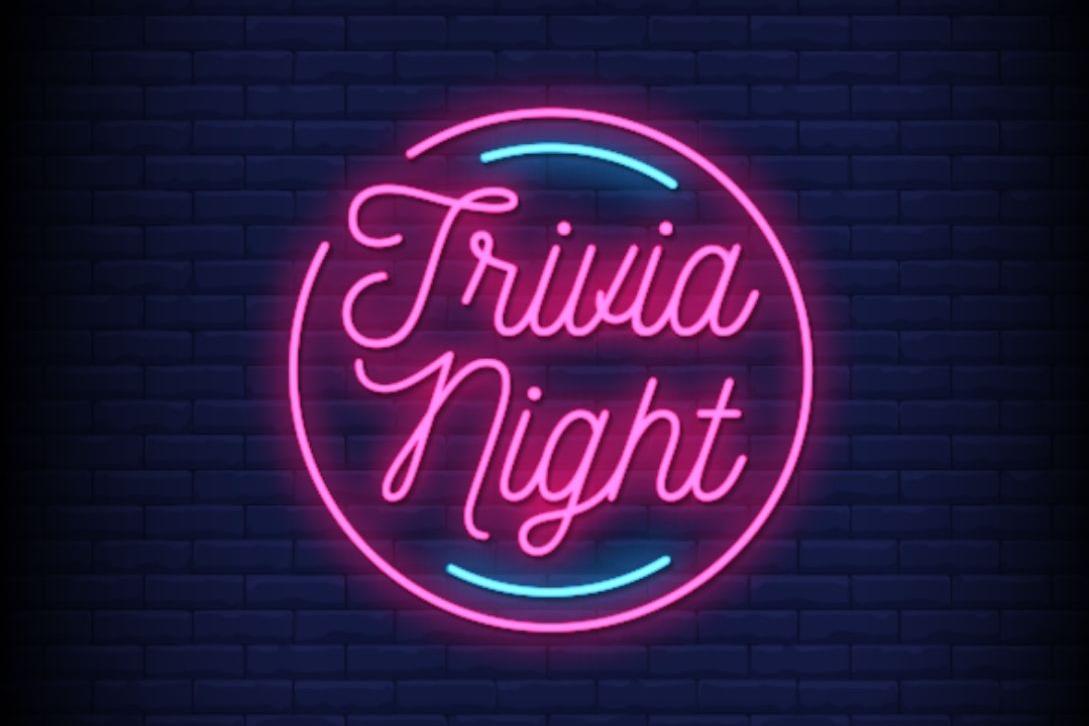 trivia night sign lit up in neon lights against a brick wall