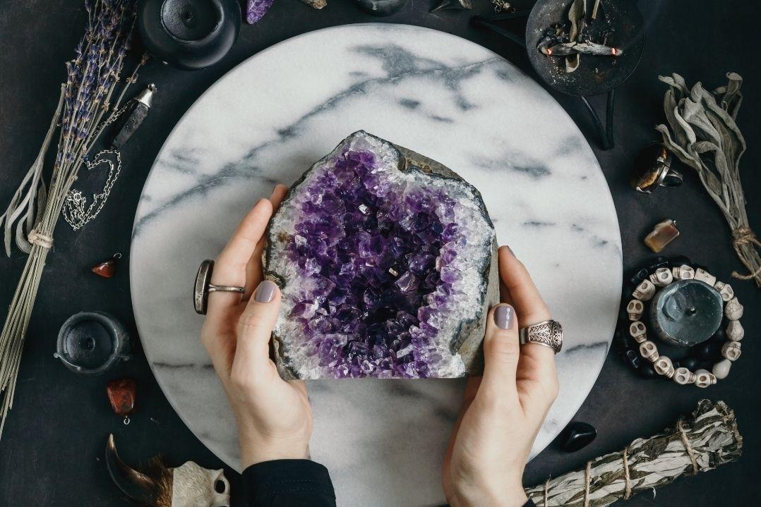 hands holding a amethyst gem stone