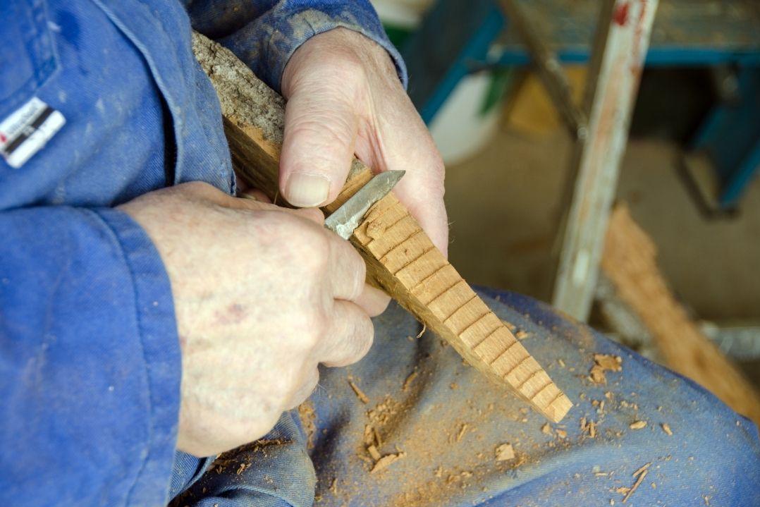 person carving wood