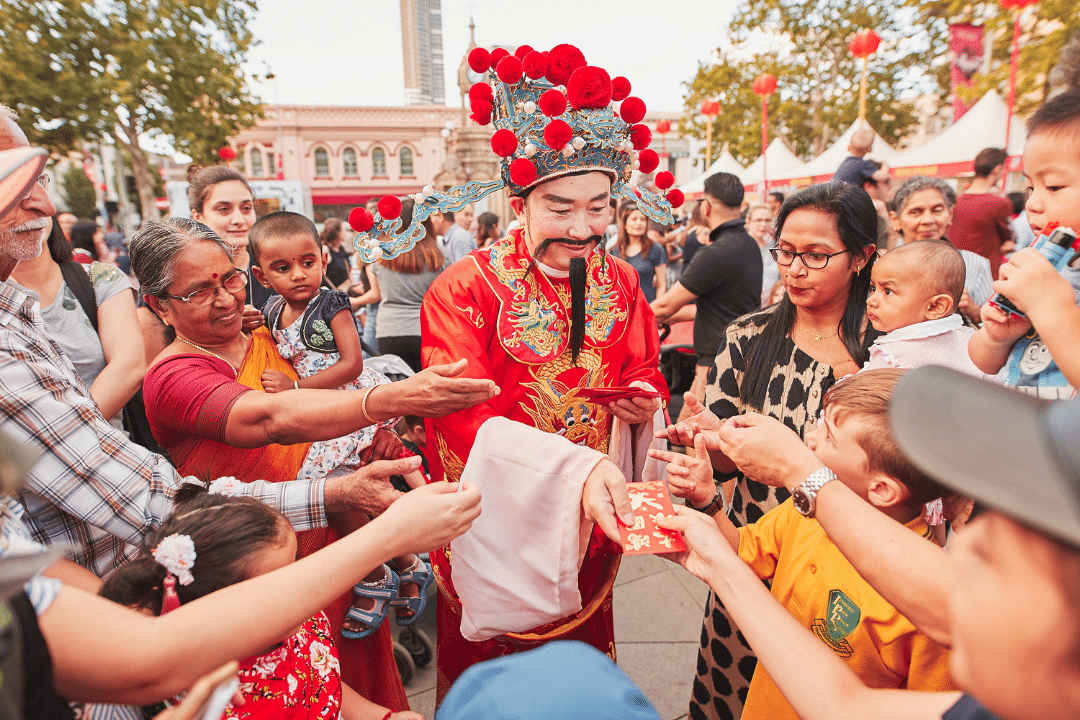 A man gives out red pockets at a Lunar New Year celebration.