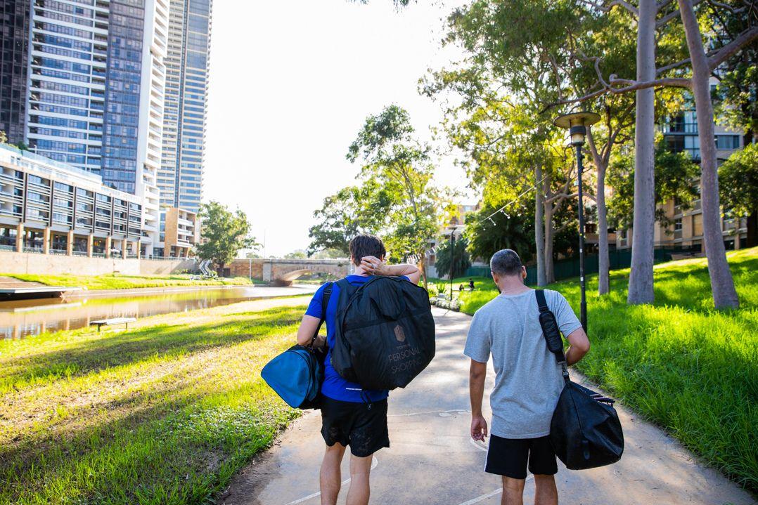 Two workers carry gym bags in Parramatta