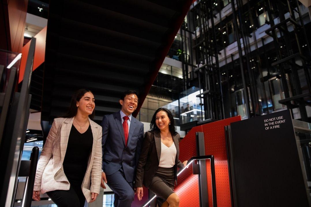 three office workers walking in a building lobby area