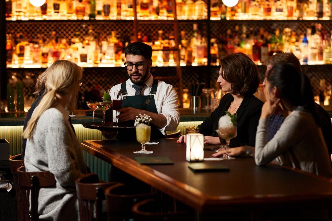 Bar tender serving people at the bar.