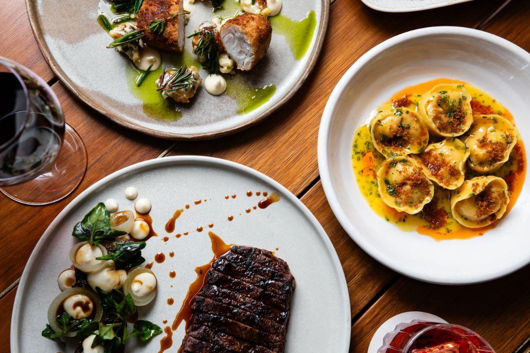 Flat lay of steak, pasta and chicken dishes