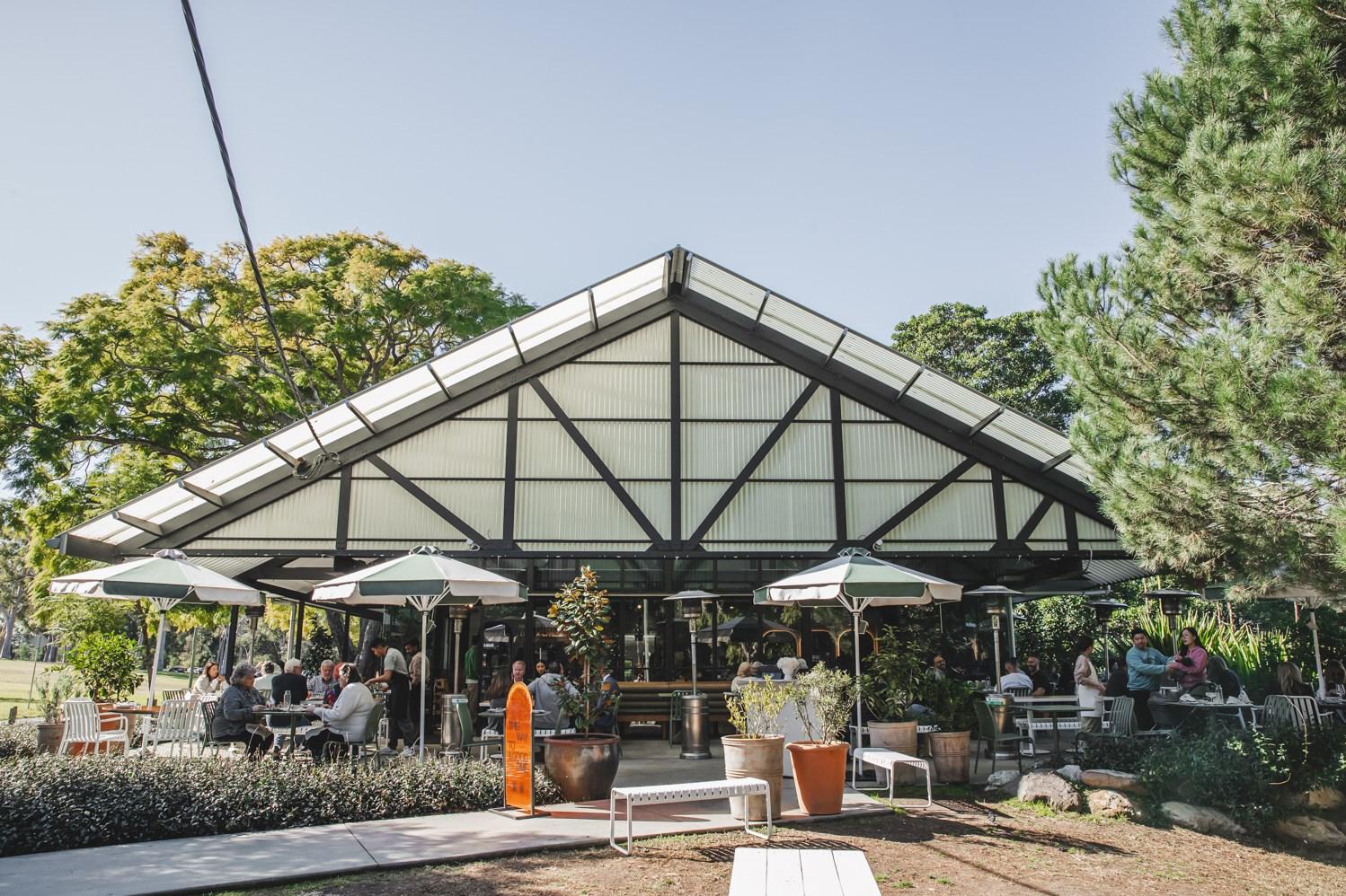 Outdoor facade of misc, including outdoor seating and umbrella shades