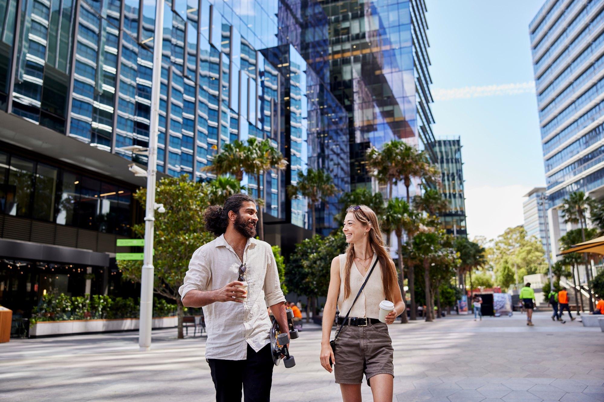 Two students walking through Parramatta Square